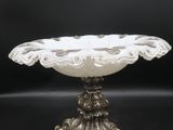 un saladier en verre blanc posé sur une table noire