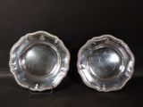 pair of silver plated dishes with beaded rims on a black background