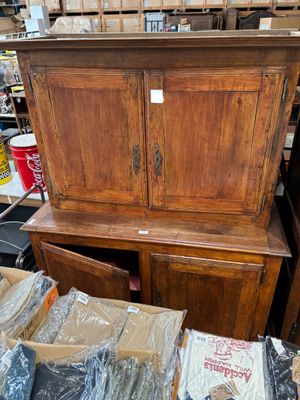 une armoire en bois posée au milieu d'une pile de cartons