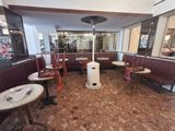 tables and chairs in a restaurant with a gas heater in the middle of the room