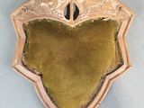 un vieux bouclier en bois recouvert de velours vert