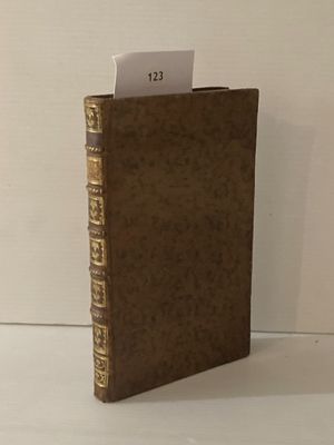un livre marron sur lequel sont inscrits des mots, posé sur une table