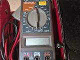 a digital multimeter in a black case with a red cord