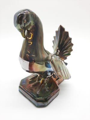 statue of a bird on a stand with a white background