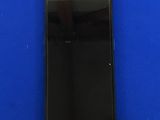 l'arrière d'un téléphone portable noir posé sur une surface bleue
