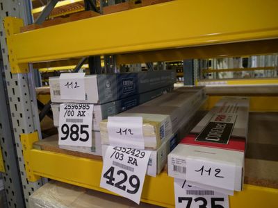 many boxes on the shelves of a store with price tags