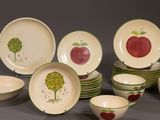 a lot of plates and bowls with apples painted on them
