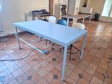 une table blanche avec un plateau bleu au milieu d'une pièce
