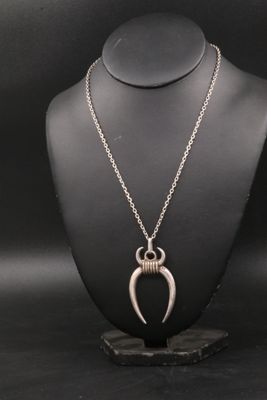 un collier en argent avec un pendentif en forme de corne sur un mannequin