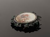 an image of a broochle with a picture of a man and a woman on it