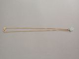 a close up of a pair of gold plated hair pins on a gray surface
