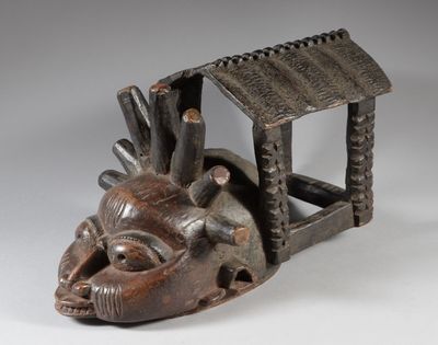une image représentant une sculpture en bois représentant la tête d'un homme surmontée d'un toit