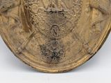 a gold plate with a coat of arms and a crown on it