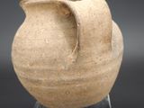 a vase that is sitting on a stand on a black surface