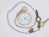 a gold pocket watch and a chain with a bird on it