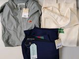 Trois pantalons pour homme et une veste sont posés sur une table