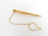 the gold tie bar is attached to the chain of the tie bar
