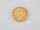 a close up of a gold coin on a white surface