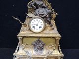 une horloge en or surmontée d'une statue