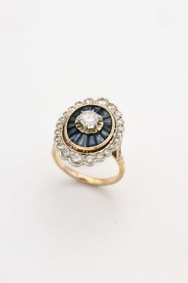 gros plan d'une bague en diamant et saphir sur une surface blanche