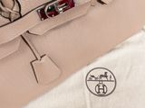 the bag is sitting on a white cloth with a red handle
