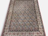 un tapis persan antique avec un motif floral sur fond blanc