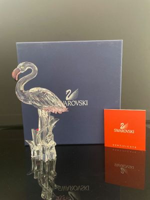 une photo d'une figurine en verre représentant un flamant rose posée sur une table