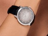 Cette femme porte une montre noire avec un cadran argenté.