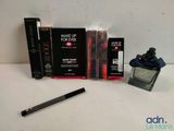 a bottle of makeup and a pen on a table