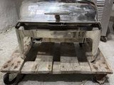 a silver grill sitting on a pallet in a kitchen