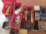 many different types of screws in boxes on the table