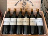 six bottles of wine in a wooden box on a table