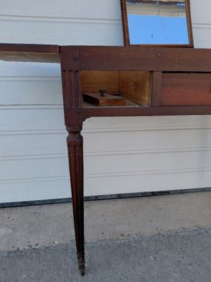 une table en bois sur laquelle se trouve un miroir, et un miroir posé dessus