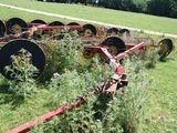 a row of old farm implements in a field