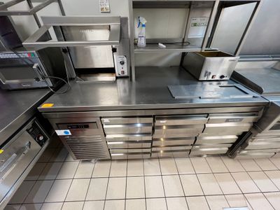 une cuisine équipée d'appareils électroménagers en inox et de plans de travail en inox