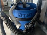 une photo d'un aspirateur bleu posé sur un plan de travail