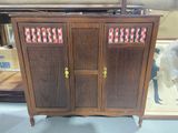 a wooden cabinet with a glass door on top of it
