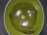 a green bowl with a pair of scissors in it