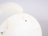 a white vase that has a hole in it