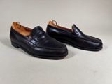 a pair of black leather shoes on a white surface