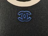 a close up of a black sweater with a blue logo on it
