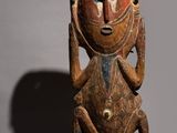 a wooden sculpture of a man with a face and legs