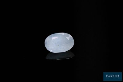 une pierre de jade blanche posée sur une surface noire