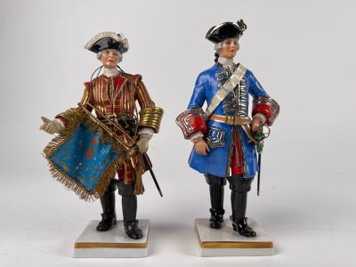 two figurines of two men dressed in military uniforms