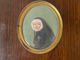 an old picture of a nun in a black robe with a cross on it