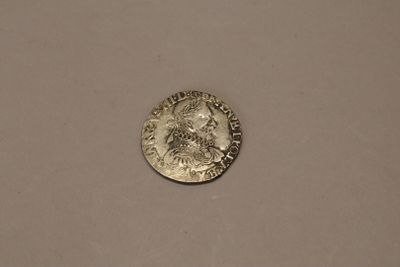 a close up of a silver coin on a white surface