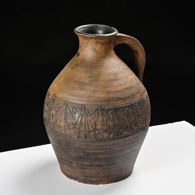 a large brown vase with writing on it on a table