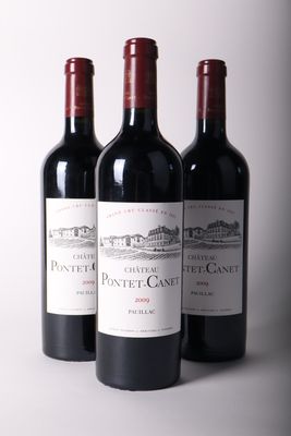 trois bouteilles de vin rouge sont alignées sur une table