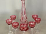 six verres à vin et une carafe posés sur une table