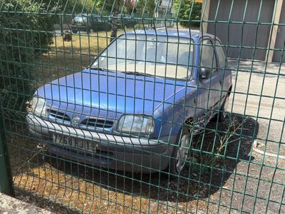 une voiture bleue garée derrière une clôture